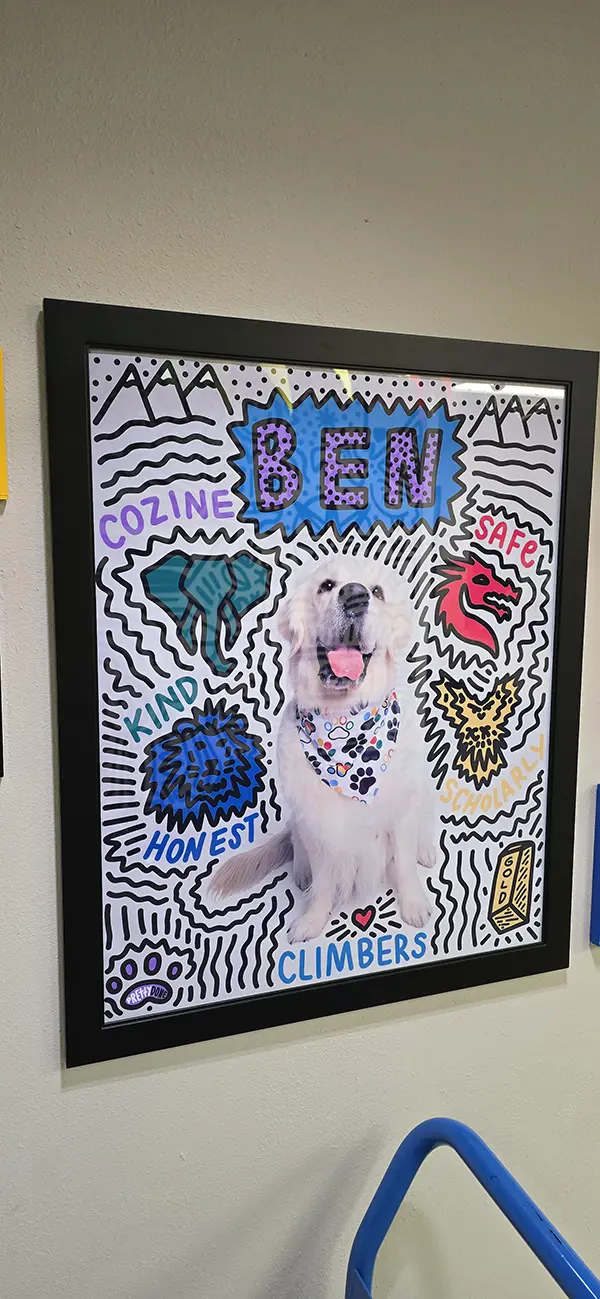 Framed poster of Ben the school dog with the four house mascots and the words kind, honest, safe and scholarly at Steve and Linda Cozine Elementary School